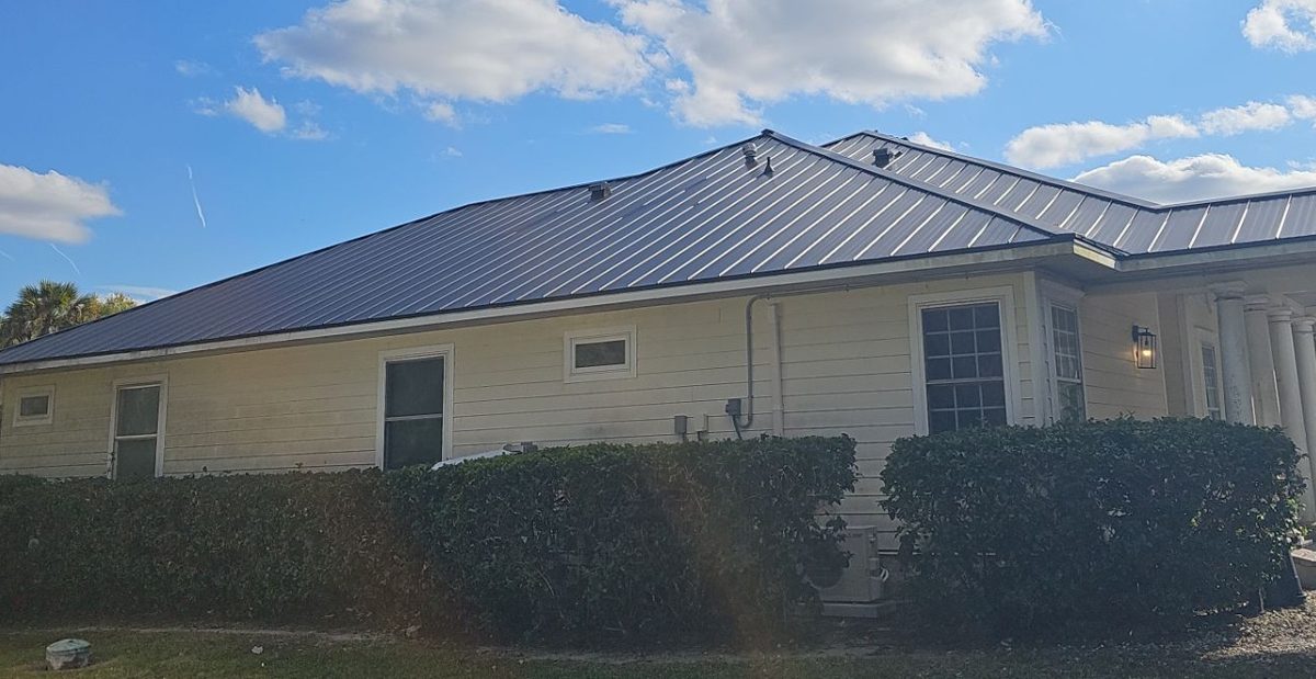 Charcoal standing seam metal roof on a single-story Florida home